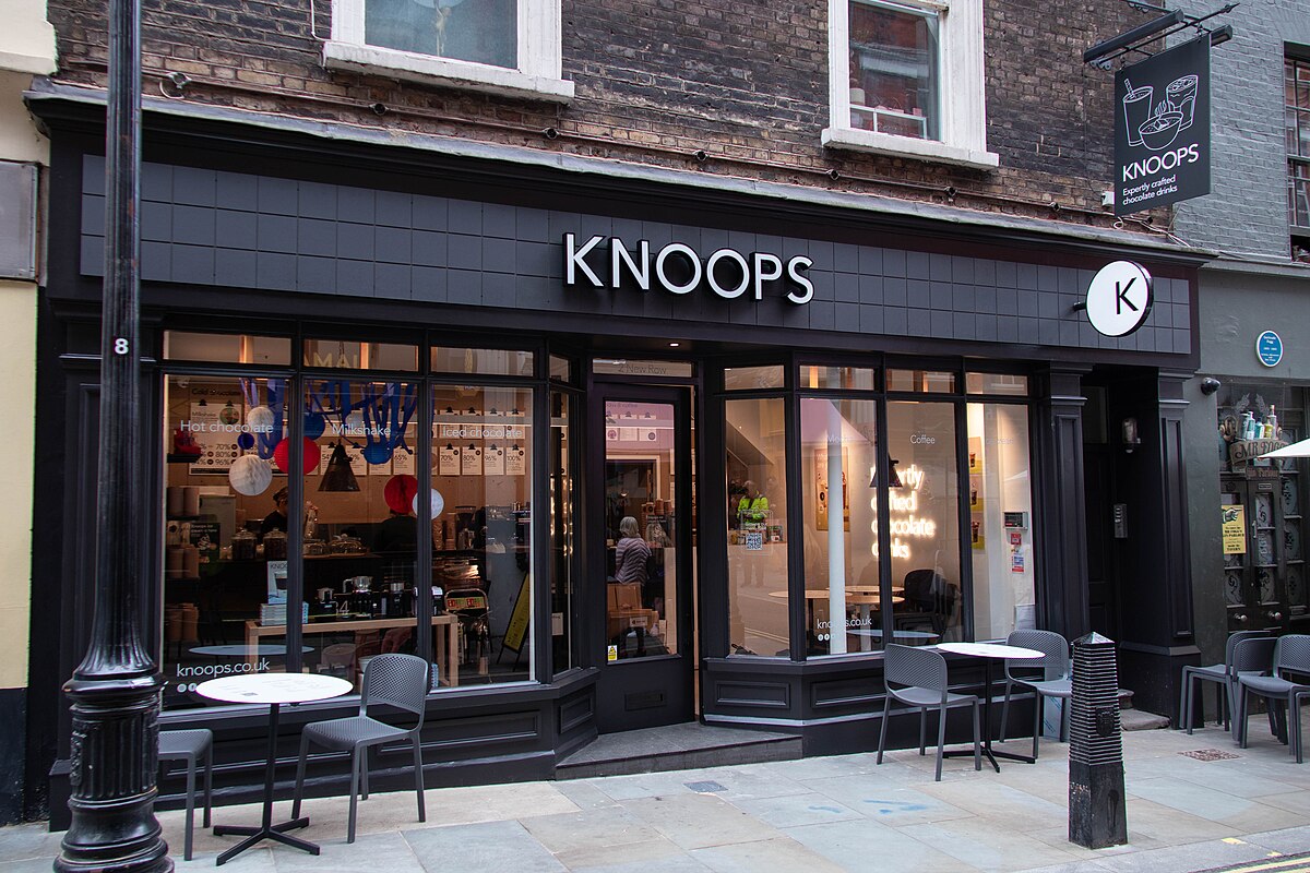Knoops storefront with modern black facade and outdoor seating